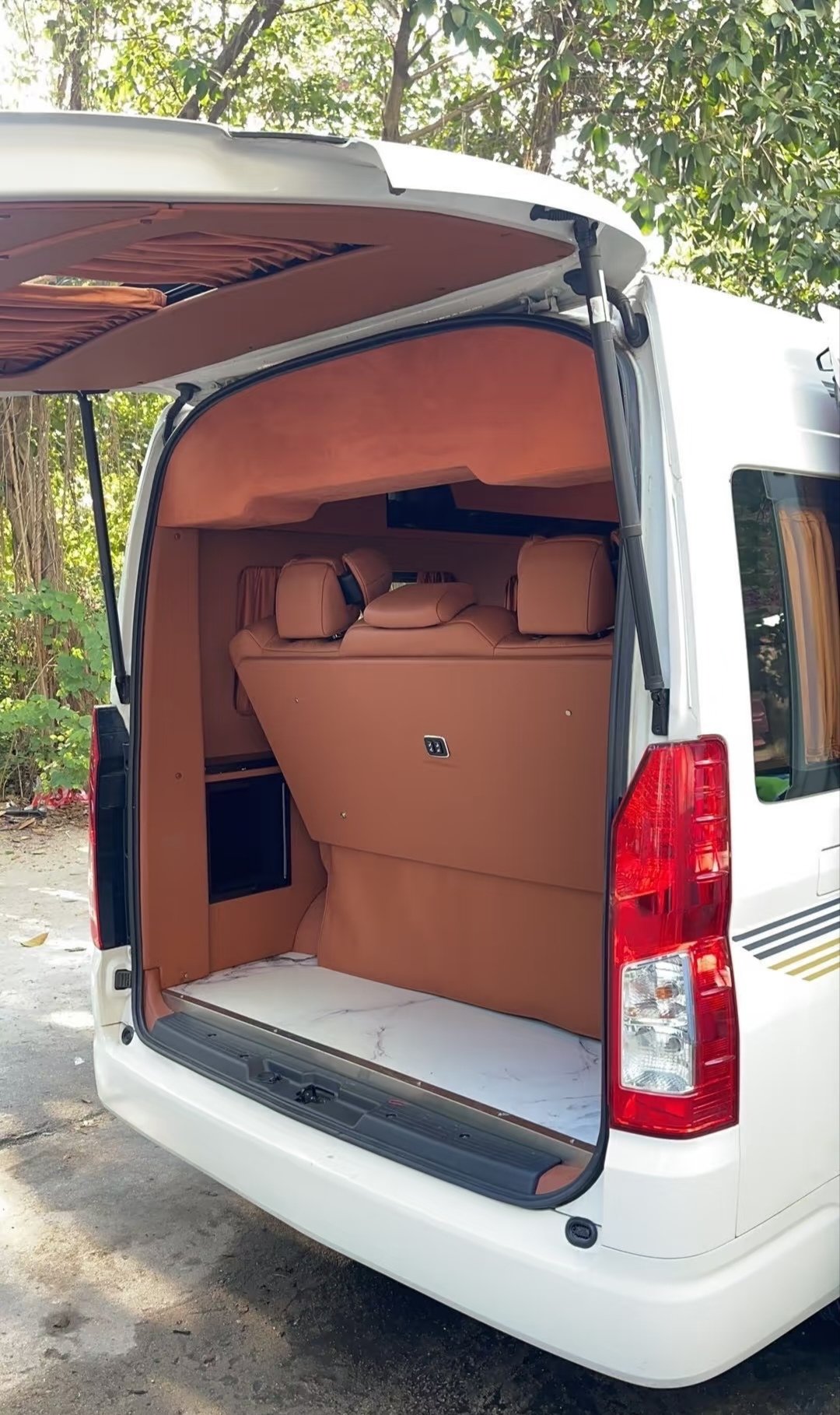 Storage area behind the final seating row in a brown Toyota Hiace interior